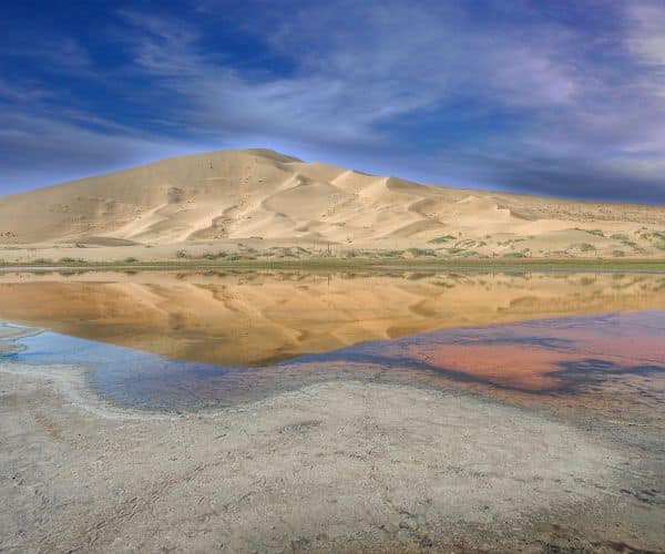 Gobi landzunge Atemberaubende Sanddünen spiegeln sich in einem See in der Wüste Gobi, Mongolei, unter einem dramatischen Himmel.