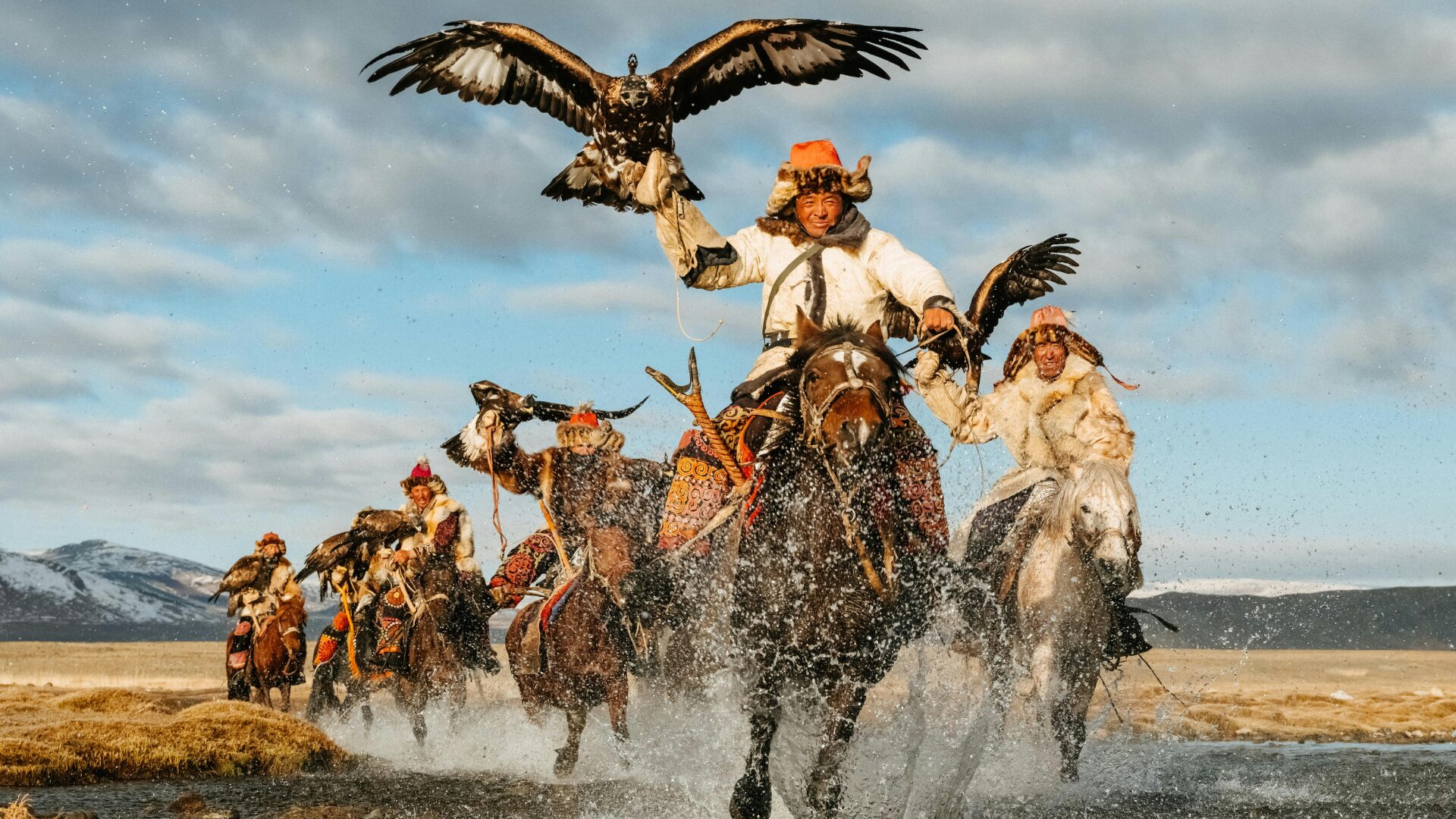 Golden Eagle Festival Mongolei - Traditionelle Reiter Mongolische Reiter mit Adlern beim Golden Eagle Festival auf Pferden in traditioneller Kleidung.