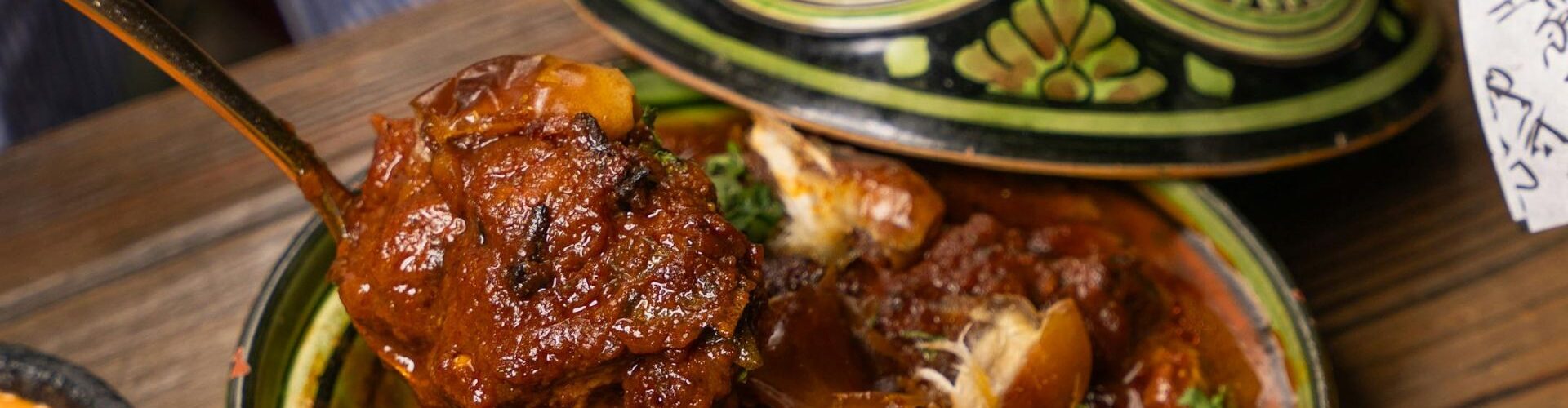 Marokkanisches Eventdinner mit Tajine und handgefertigter Keramik – Gast genießt traditionelle Küche in authentischer Atmosphäre.