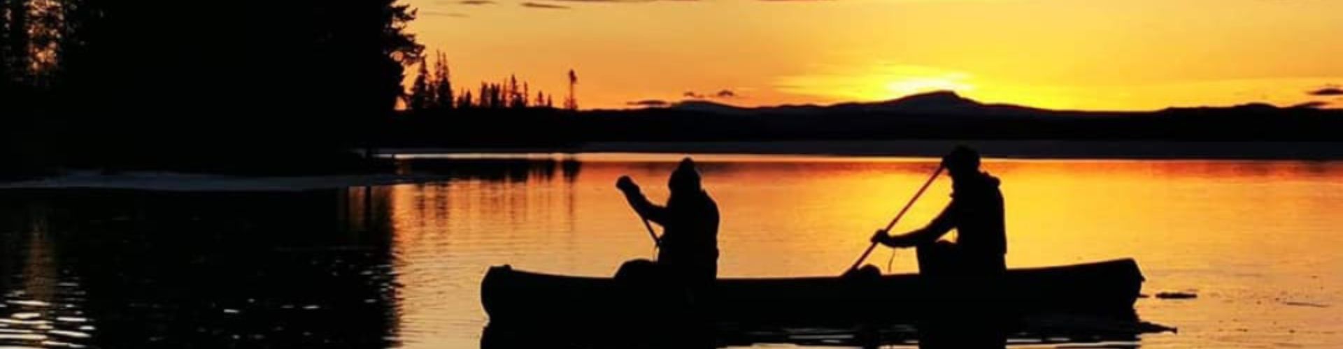 Marokko Wüstentour – Kamel in der Sahara bei Sonnenuntergang Paddeltour im Sonnenuntergang auf einem See in Schwedischen Sommer Lappland – zwei Personen im Kanu vor glühendem Himmel und stiller Naturkulisse.
