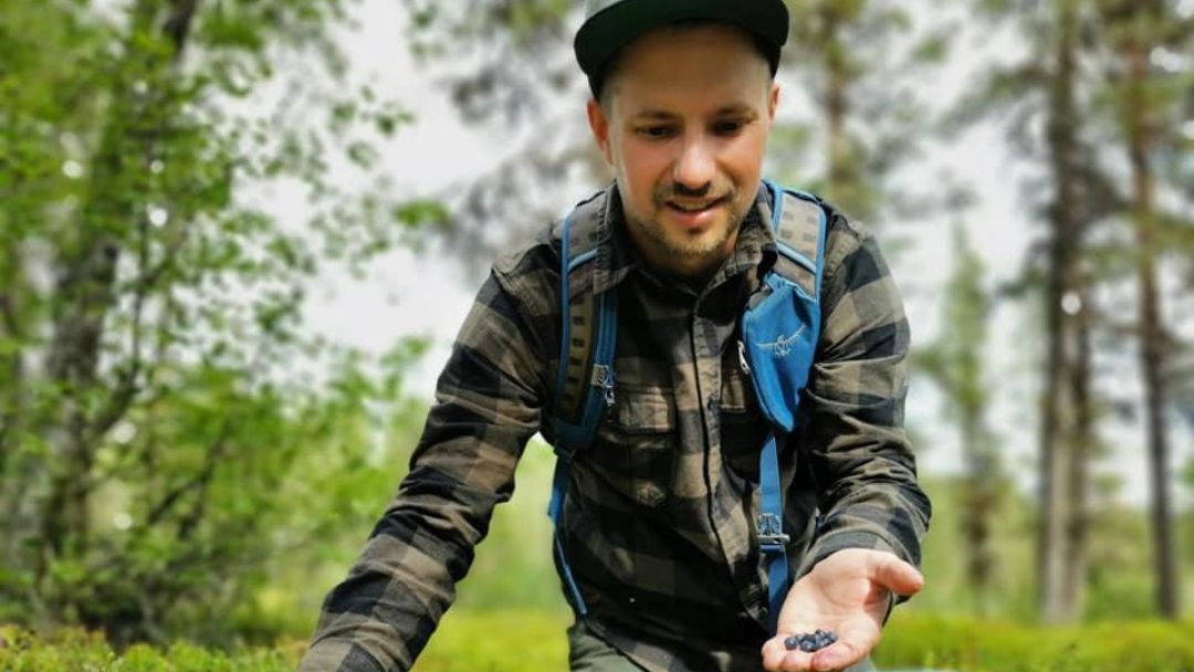 Reiseleiter Mongolei Nurbie Outdoor-Guide beim Sammeln von Blaubeeren in der Wildnis Lapplands – naturverbunden und erfahren im Trekking.