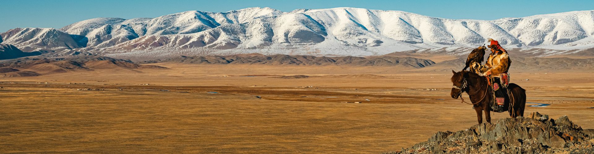 Westmongolei Adlerjäger zu Pferd in der Westmongolei vor verschneitem Altai-Gebirge