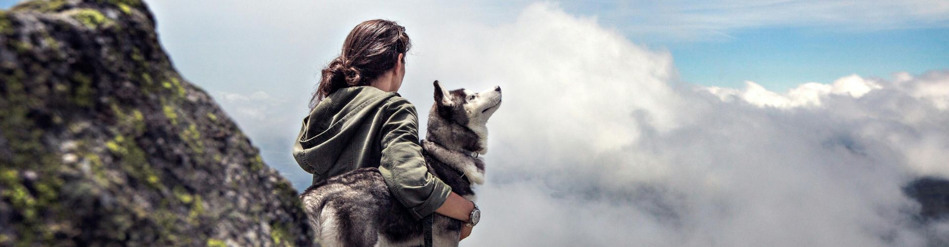 Westmongolei Frau mit Husky auf einem Berg, umgeben von Wolken – Sommerabenteuer mit Schlittenhunden in Lappland"