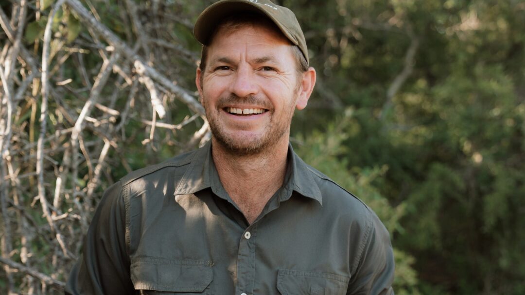 Wayne, erfahrener Guide der Gabon Wilderness Experience, vor grünem Buschland