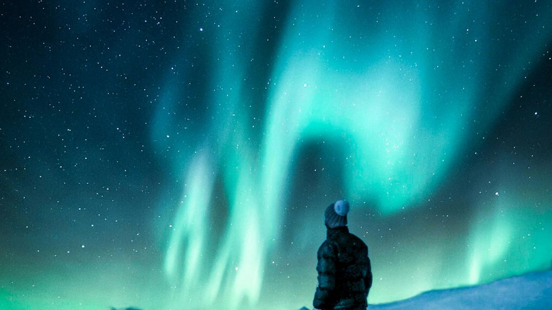Polarlichter Schweden am Polarkreis in grün mit einem Mann im Vordergrund<br />

