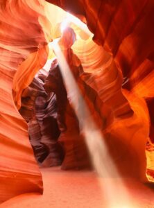 Sonnenstrahl dringt von oben in den Antelope Canyon und taucht die Felsformationen in warmes Licht.