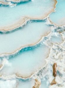 Natürliche Kalkterrassen der Thermalquellen von Saturnia in Italien, gefüllt mit türkisblauem, warmem Thermalwasser.